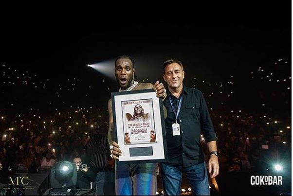 Burna Boy with plaque at SSE Arena
