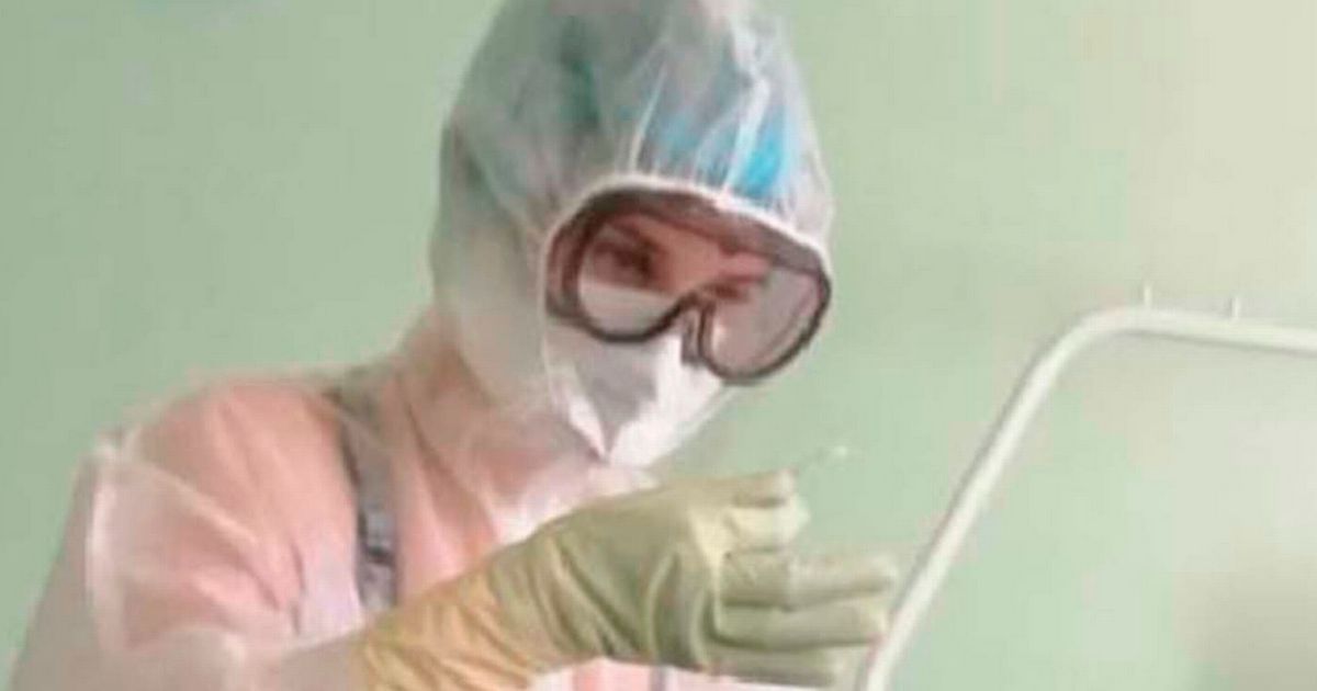 Nurse pictured in a male ward wearing only lingerie under protective gown